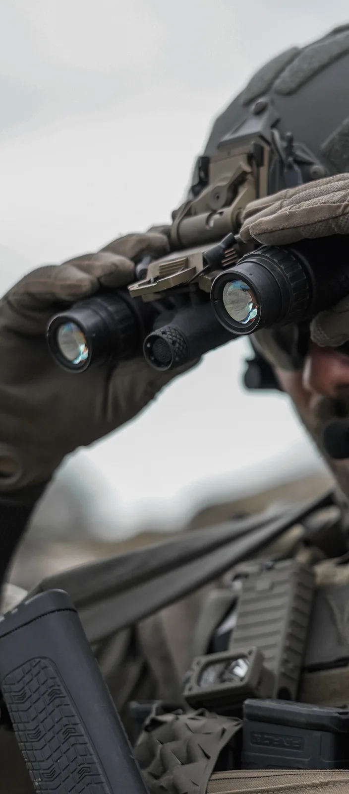 Monoculaire LNVM tenu en main sur le terrain, objectif vers l'avant
